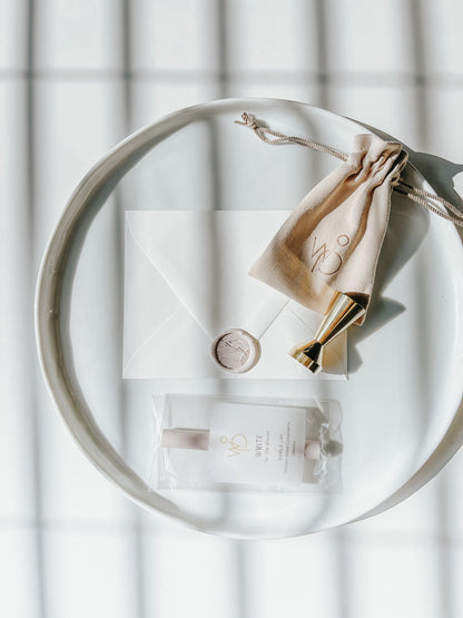 Sand dunes wax seal stamp with a blush wax seal on an envelope, gold brass stamp, and sealing wax set, styled on a white tray