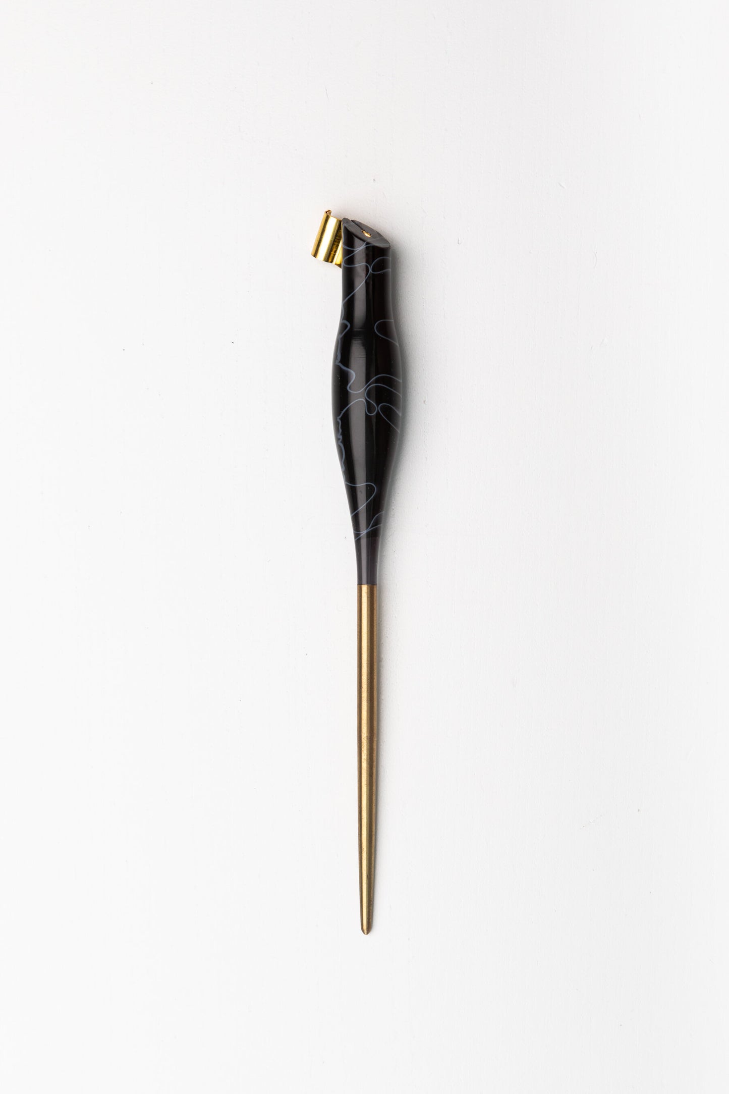 Handmade oblique calligraphy pen with a sleek black resin body, ergonomic grip, brass tip, and elegant white swirl design
