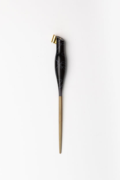 Handmade oblique calligraphy pen with a sleek black resin body, ergonomic grip, brass tip, and elegant white swirl design