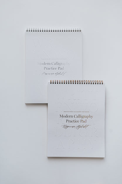 Two modern calligraphy practice pads for uppercase and lowercase alphabets, featuring sleek spiral binding on a white background