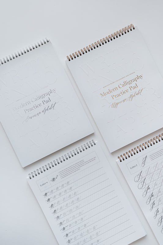 Four modern calligraphy practice pads featuring uppercase and lowercase alphabet exercises, displayed on a white background