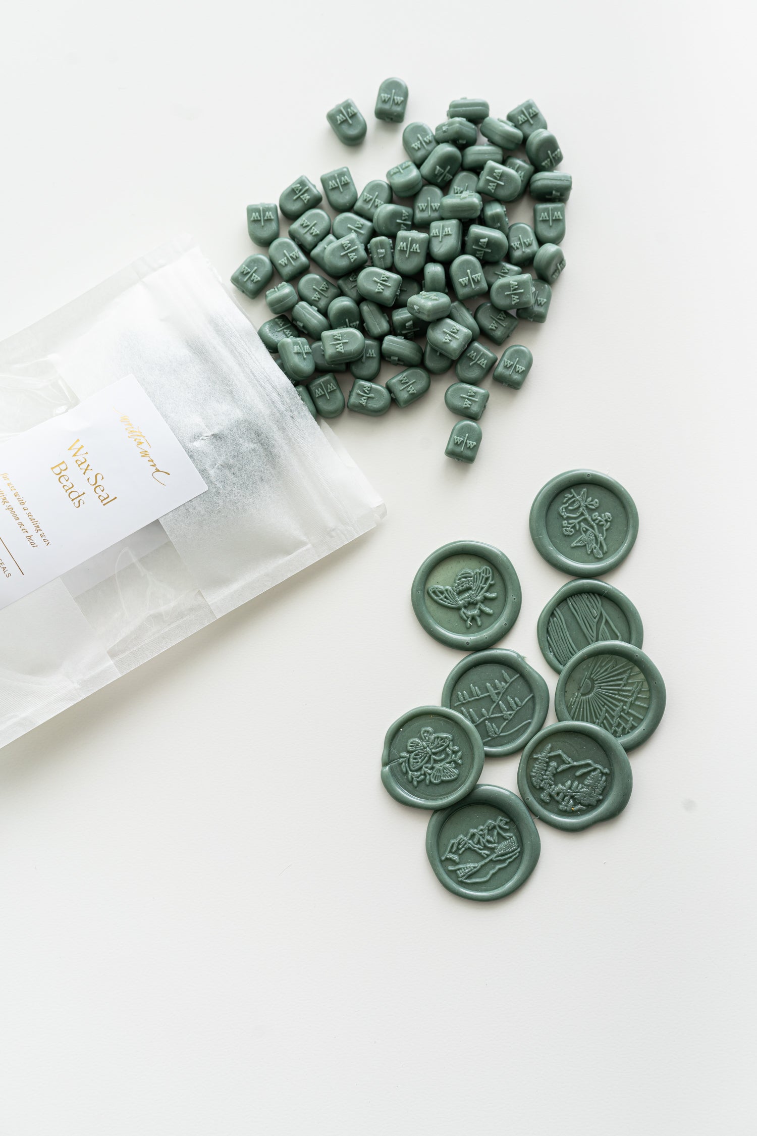 Forest green wax seal beads with finished wax seal impressions for stationery