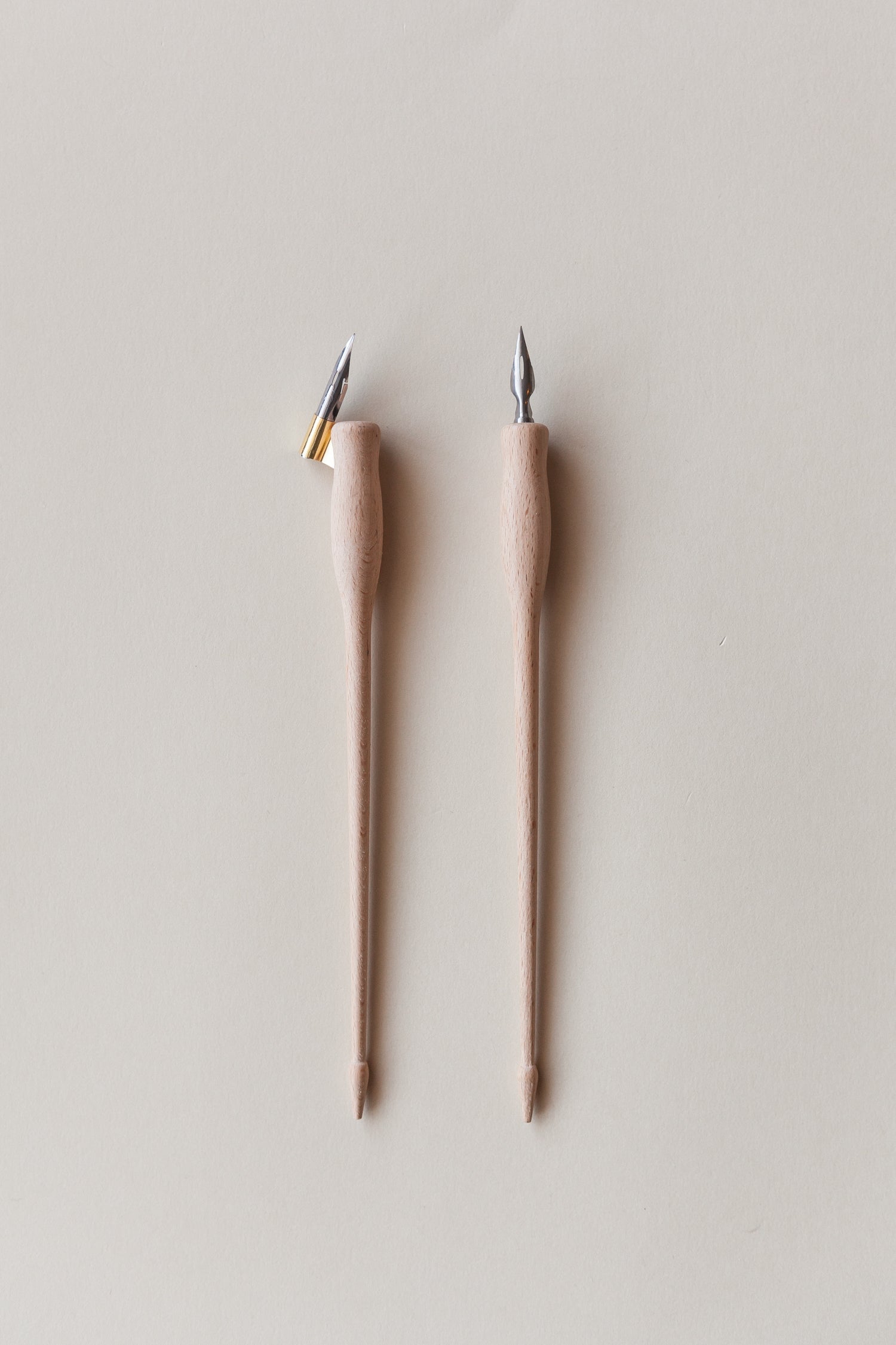 Two dual-purpose calligraphy pens with wooden bodies, shown with straight and oblique brass flanges, ideal for modern calligraphy