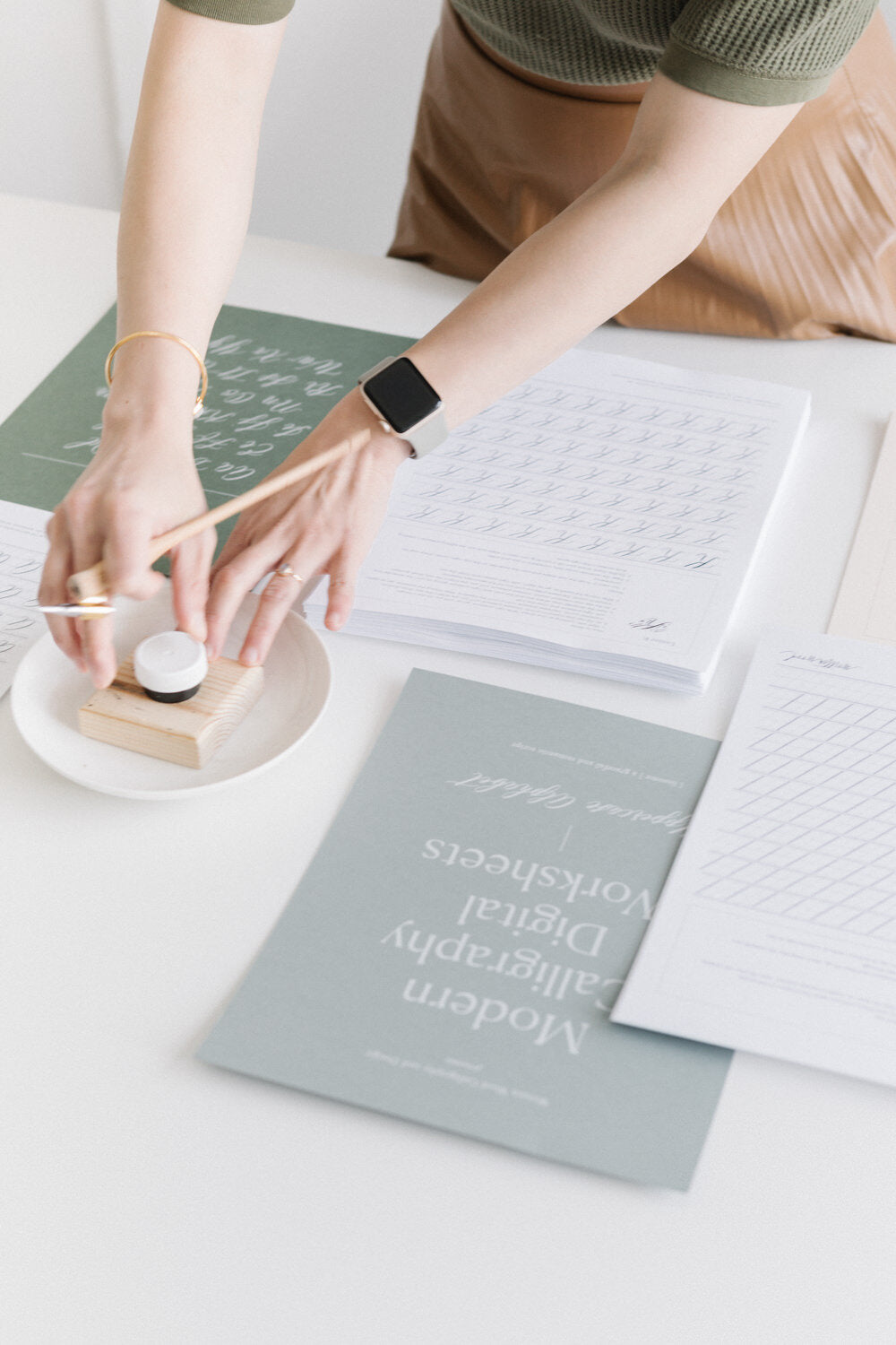 Preparing ink for calligraphy practice with pen holder and modern calligraphy worksheets