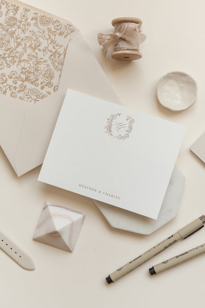 Personalized wedding invitation suite with monogram crest, calligraphy names, and envelope styling