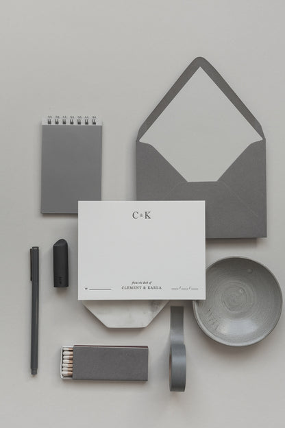 Neutral grey personalized stationery set with envelope, card, pen, matches and minimalist desk styling