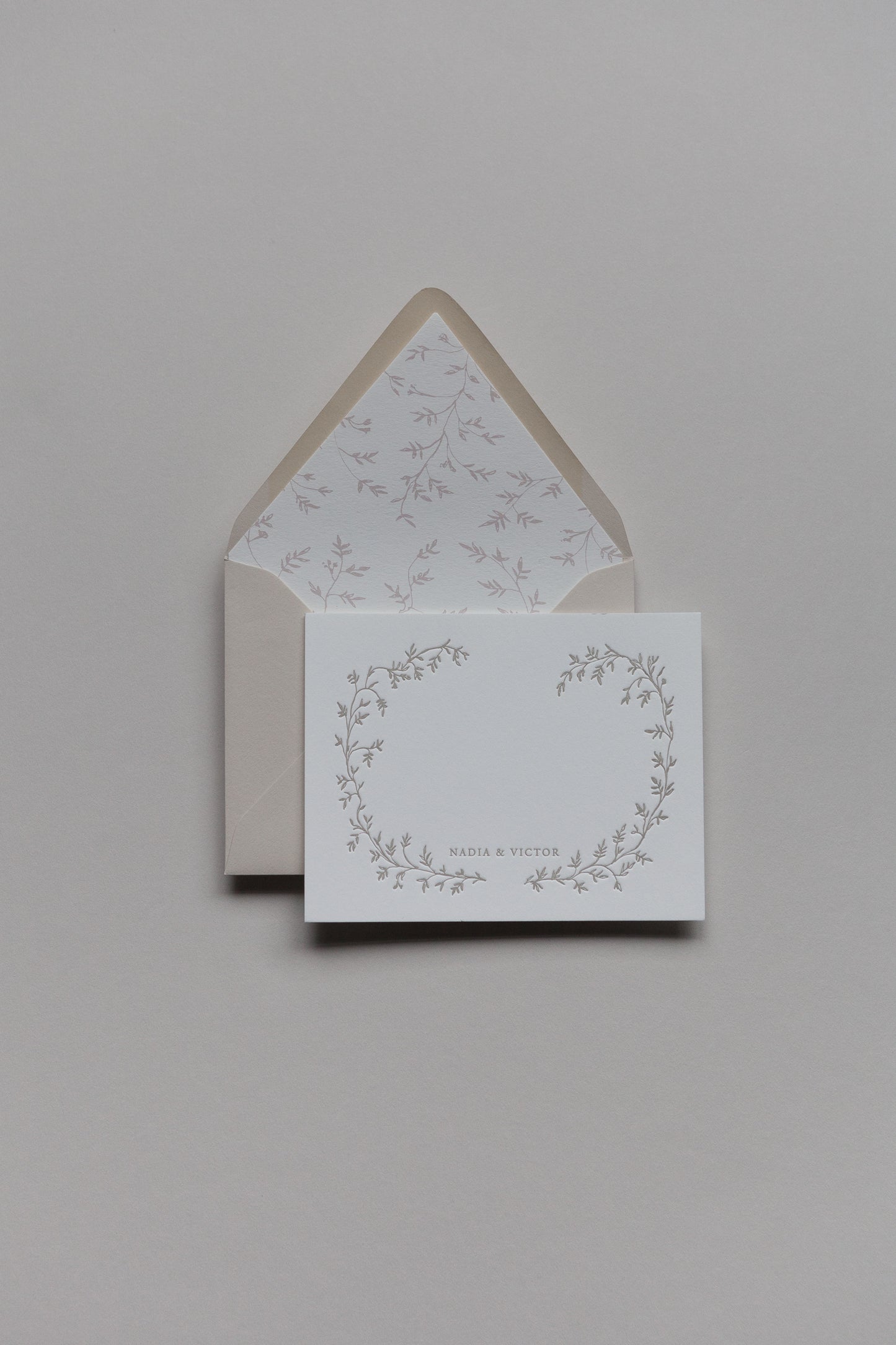 Custom stationery set with floral wreath design, personalized names, and lined envelope