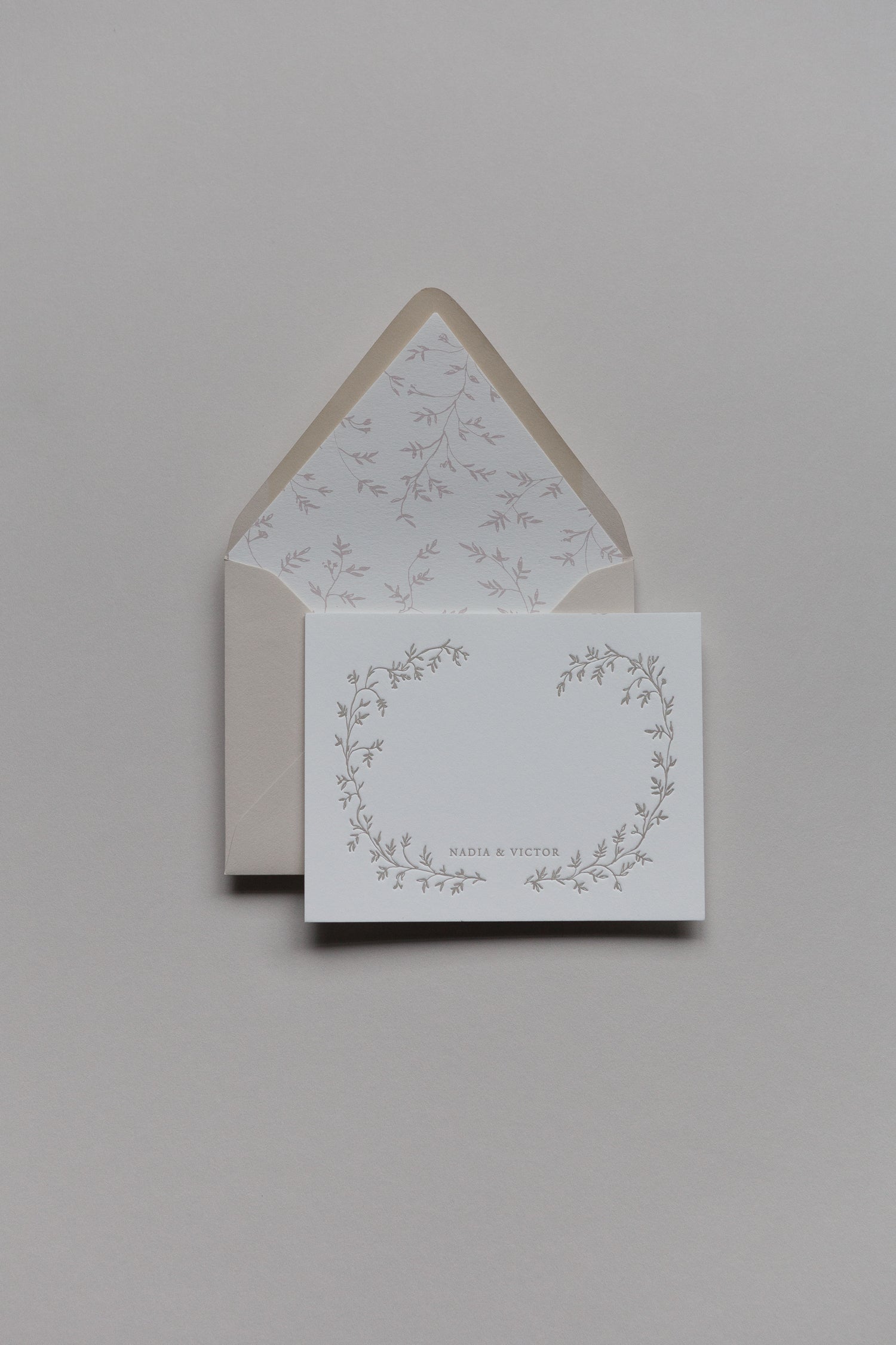 Custom stationery set with floral wreath design, personalized names, and lined envelope