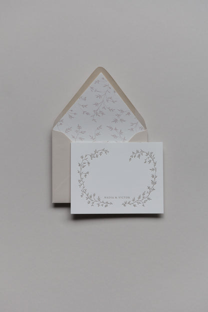 Custom stationery set with floral wreath design, personalized names, and lined envelope